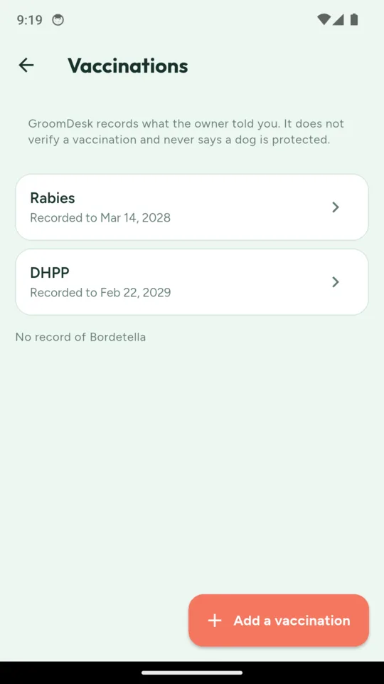 A vaccinations screen stating that GroomDesk records what the owner told you and never says a dog is protected, listing rabies recorded to March 2028 and DHPP to February 2029, and noting no record of bordetella