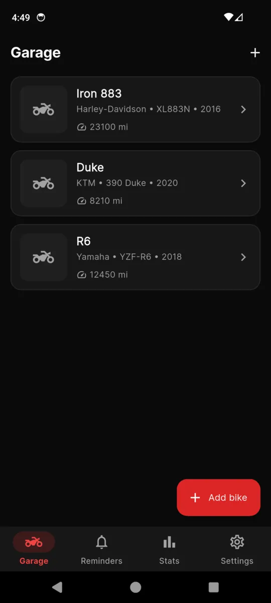 The MotoGarage garage list with three bikes, each showing its make, model, year and current odometer