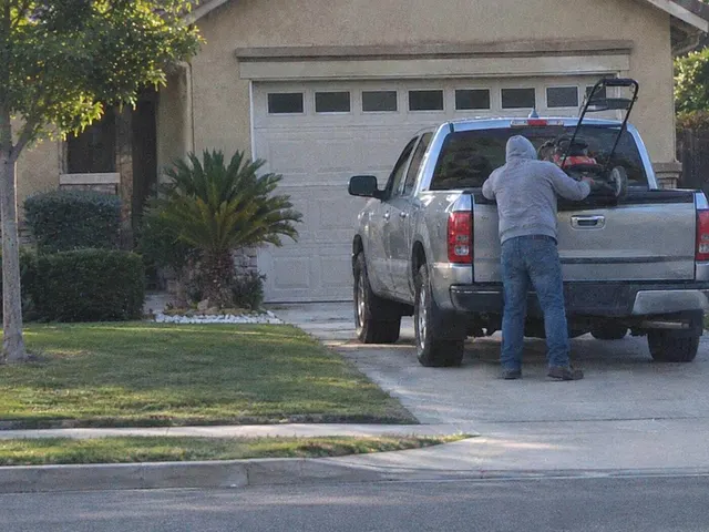 A closer frame of the same man leaning into the truck bed