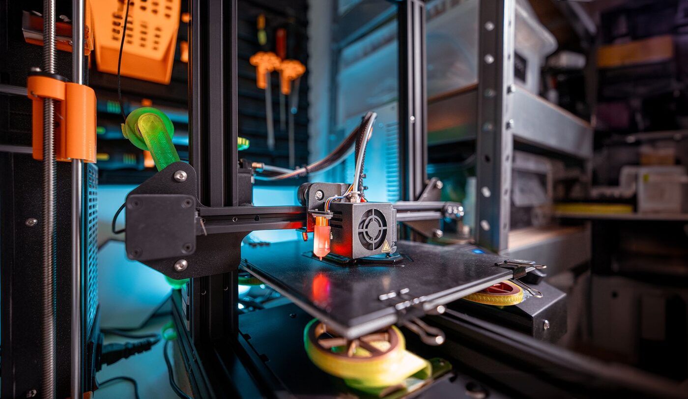 A 3D printer mid-print in a workshop, viewed close up