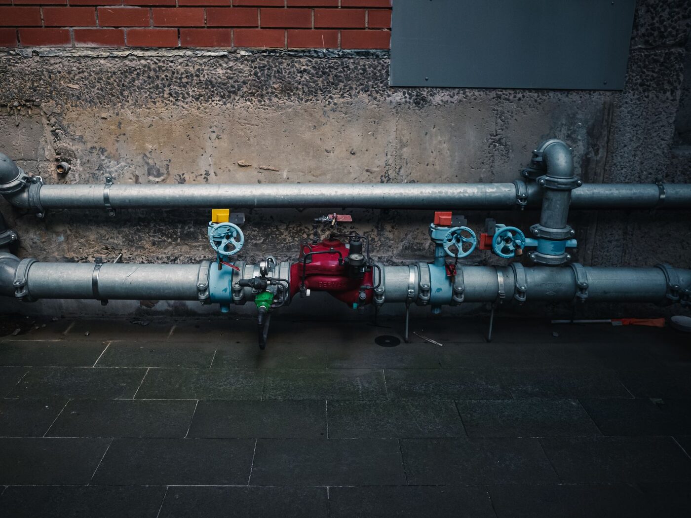 An above-ground backflow assembly with shutoff valves mounted on a wall