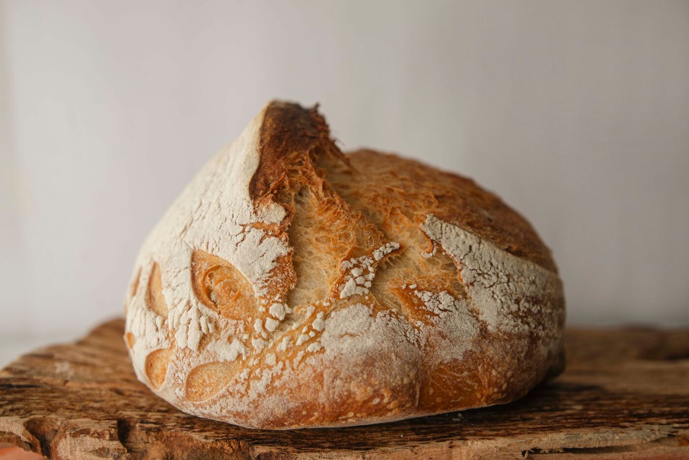 A finished artisan sourdough loaf on a wooden board