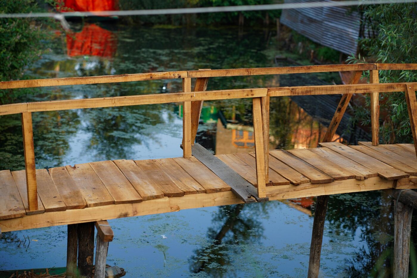 A wooden footbridge crossing still water