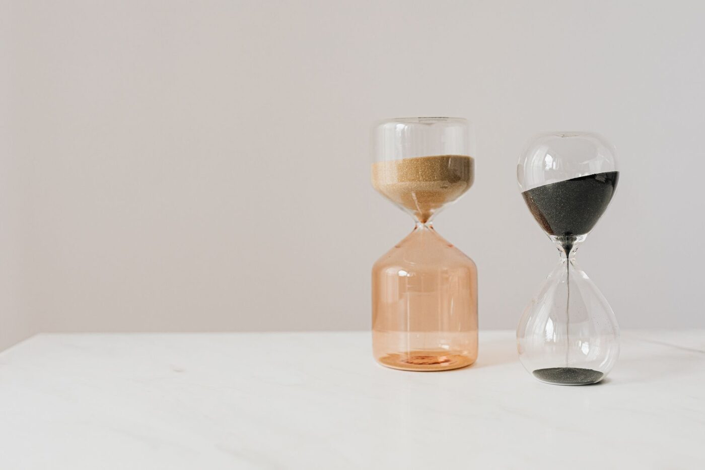 Two hourglasses on a white surface