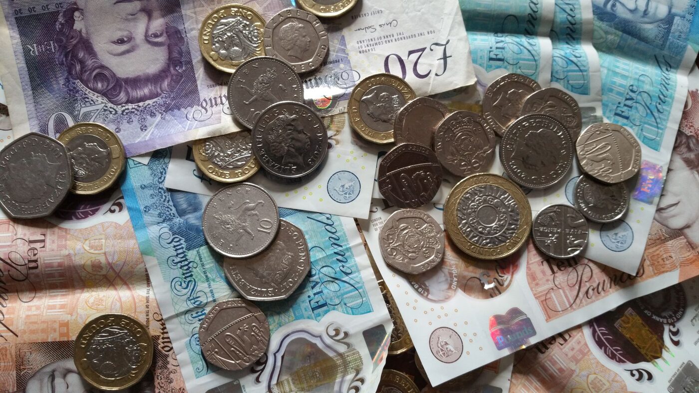 British pound coins and banknotes spread across a surface