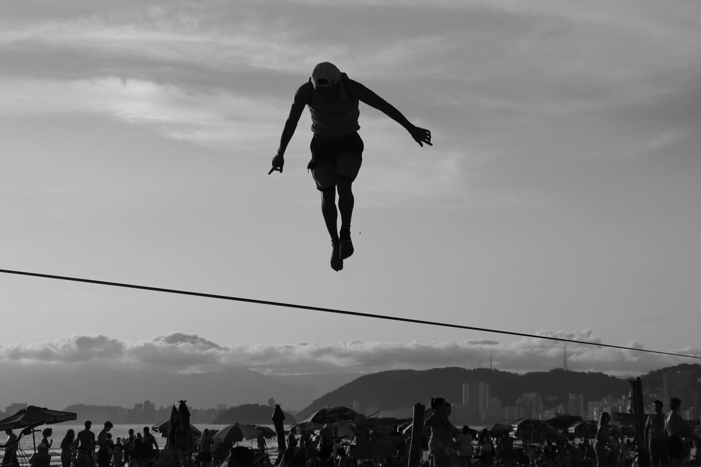 A person balancing on a tightrope against the sky