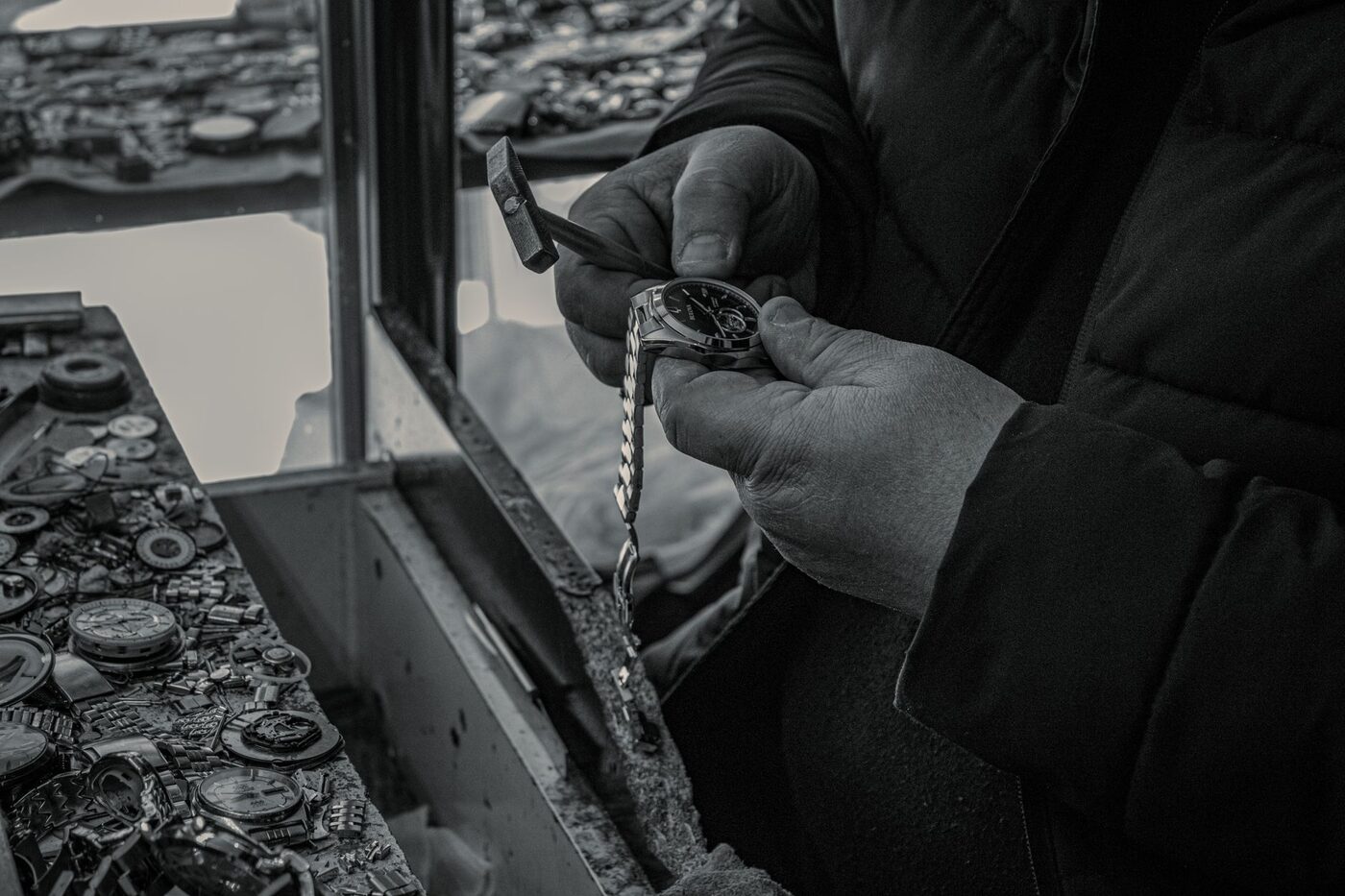 A watchmaker working on a wristwatch movement at the bench with hand tools