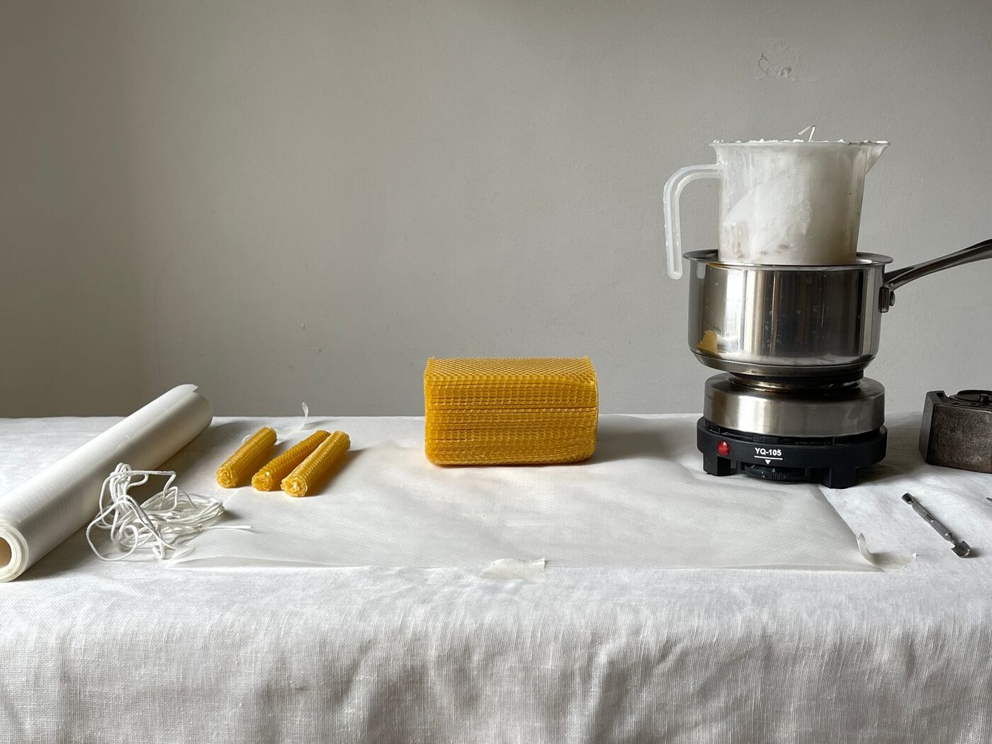 Candle making equipment and beeswax laid out on a table
