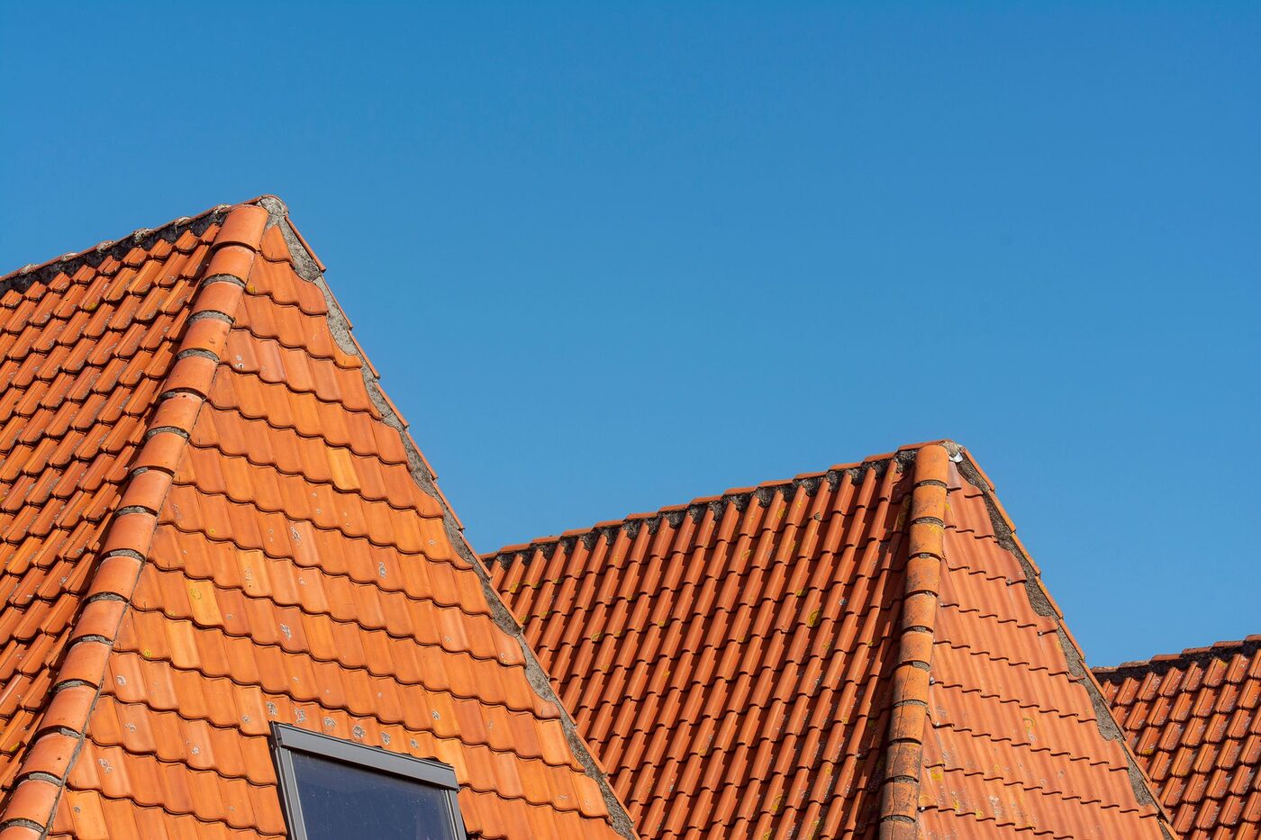 Tiled house roofs against a clear blue sky