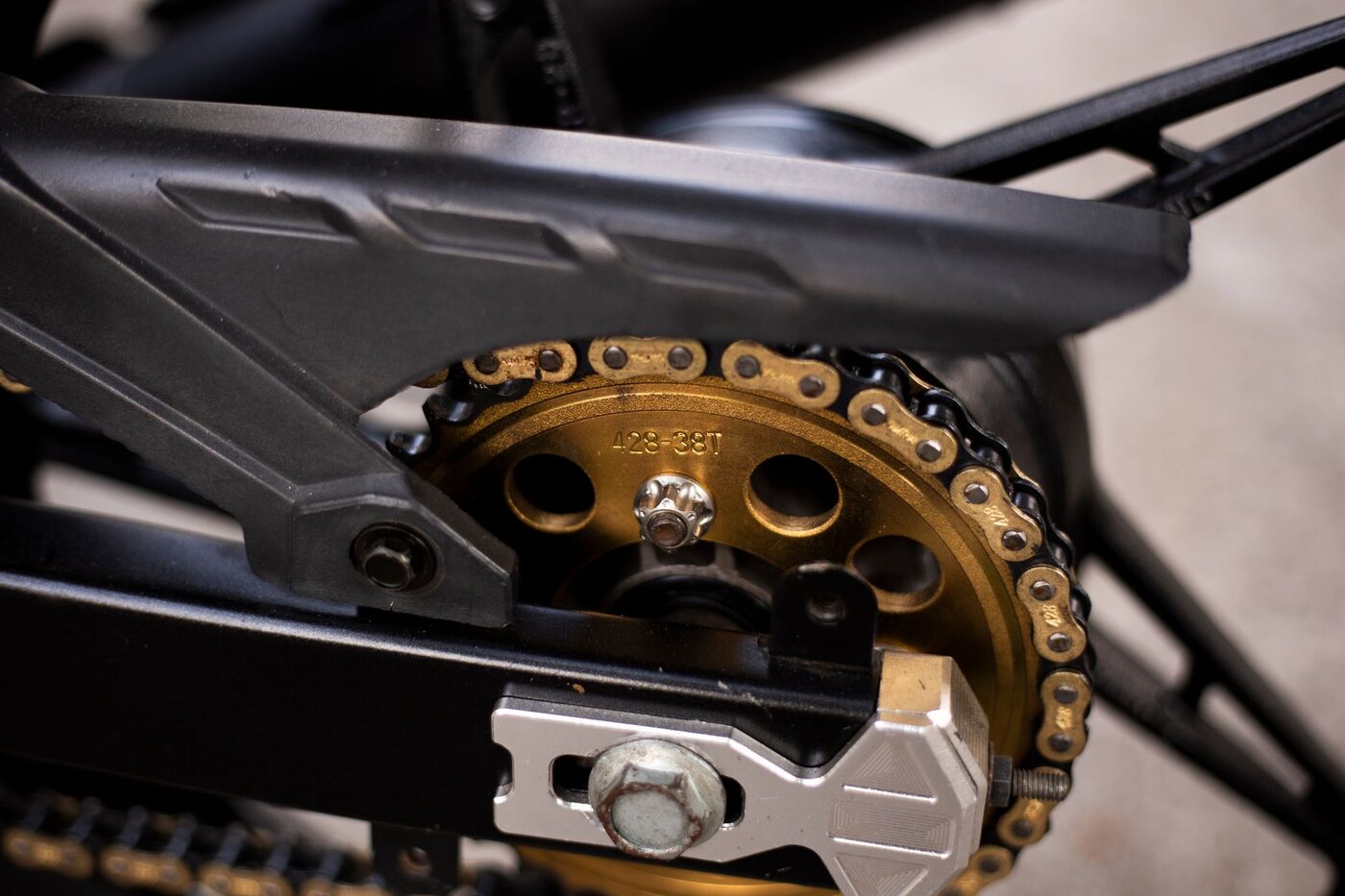Close-up of a motorcycle chain and rear sprocket