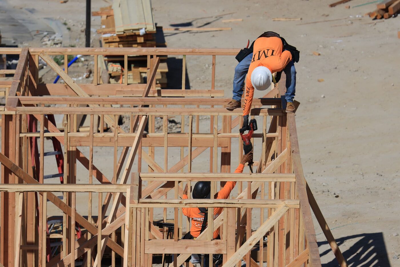 Two construction workers framing a timber structure on a building site