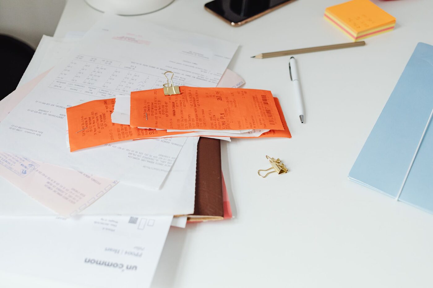 Receipts, invoices and paperwork spread across a desk