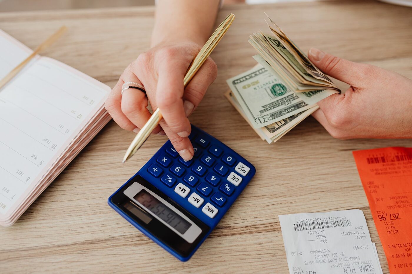 A person working through figures with a calculator and paperwork