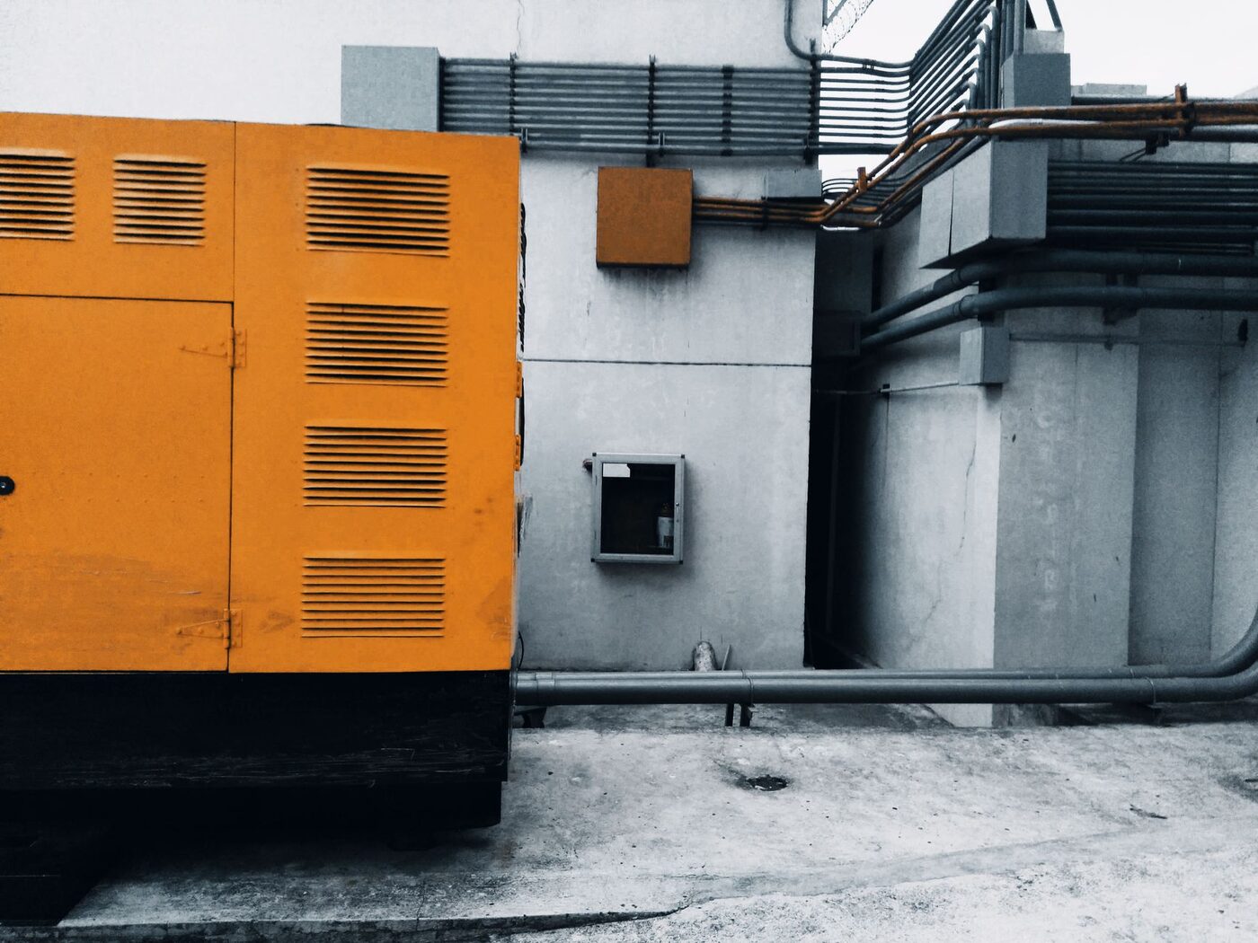 An enclosed standby generator installed outdoors alongside a concrete building