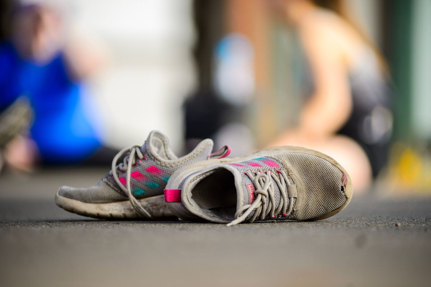 A worn pair of running shoes on pavement